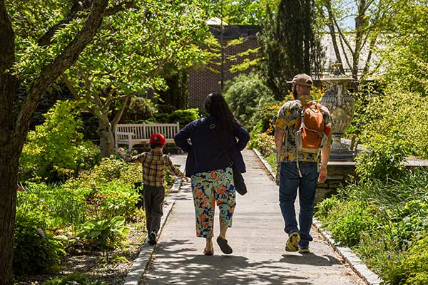 Parents and their child walking along the pathway of the Garden